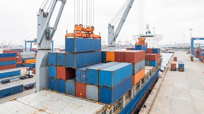 Cranes loading shipping containers onto a cargo ship at a port